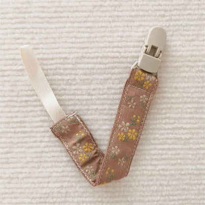 attache sucette nomade fleur jaune