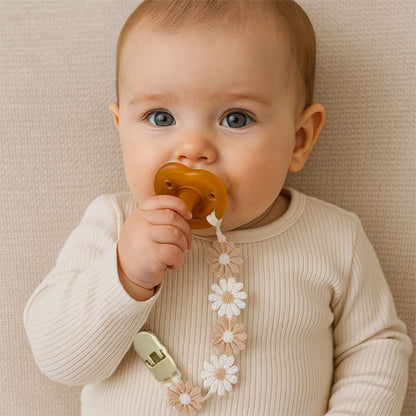 bébé avec attache tétine fleurie