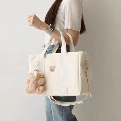 maman portant sac a langer bebe blanc debout